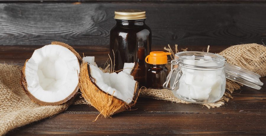 Broken coconut on a dark aged wooden table close up
